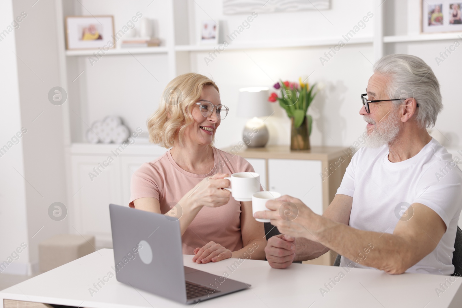 Photo of Senior man and mature woman with coffee spending time together at home. Happy couple