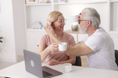 Photo of Senior man and mature woman spending time together at home. Happy couple