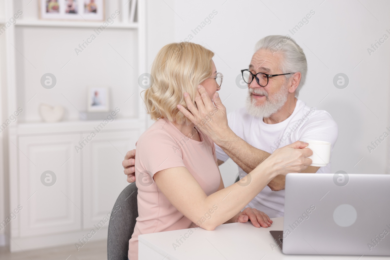 Photo of Senior man and mature woman spending time together at home. Happy couple