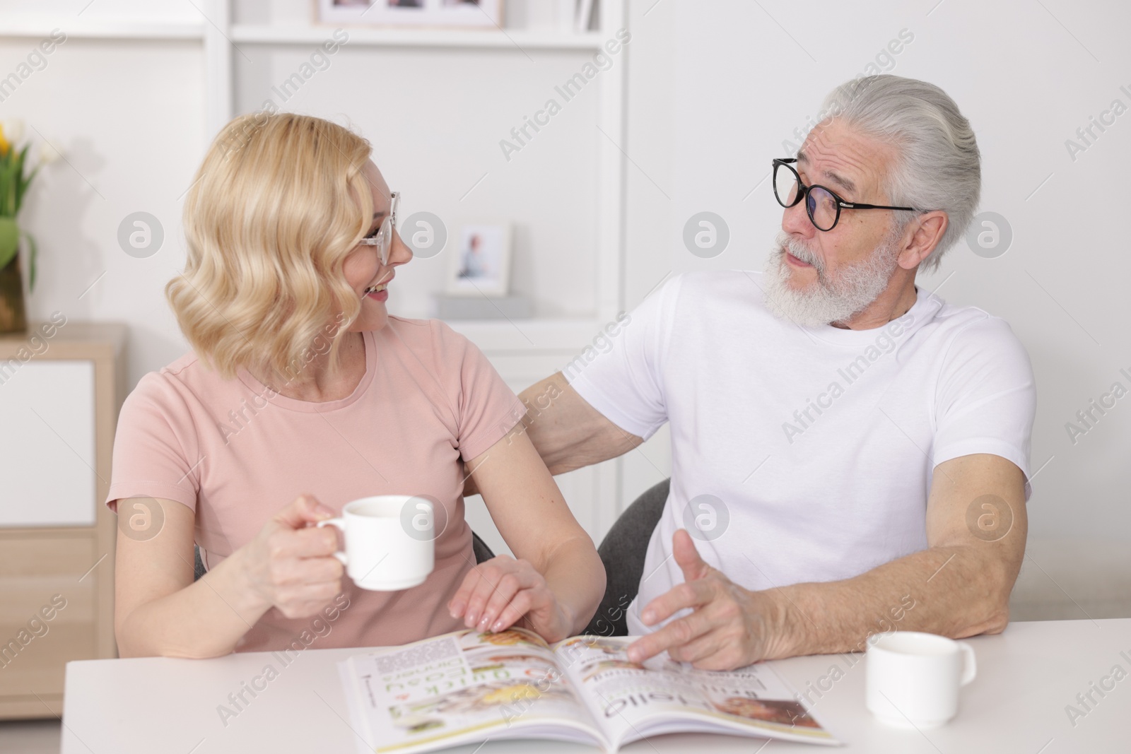 Photo of Senior man and mature woman spending time together at home. Happy couple