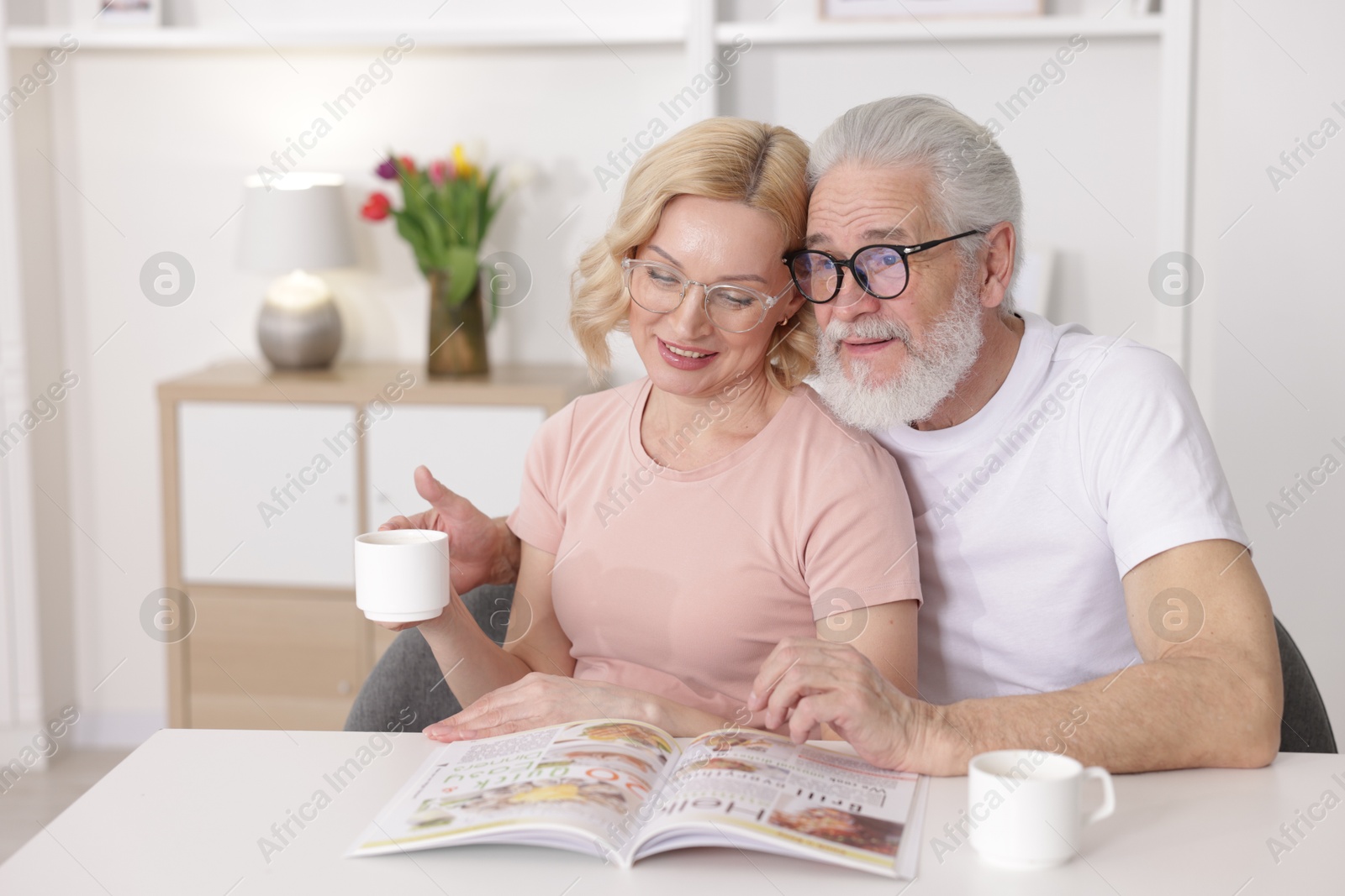 Photo of Senior man and mature woman spending time together at home. Happy couple