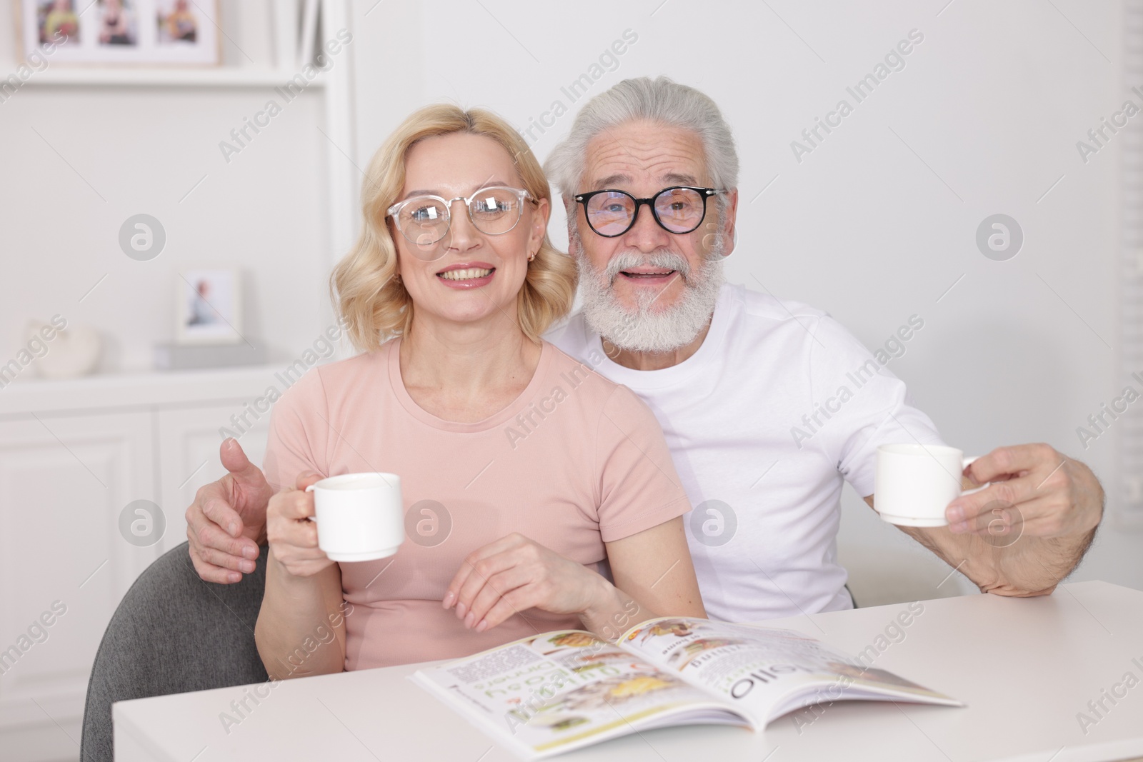 Photo of Senior man and mature woman with coffee spending time together at home. Happy couple