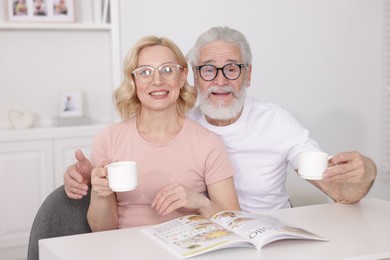 Photo of Senior man and mature woman with coffee spending time together at home. Happy couple