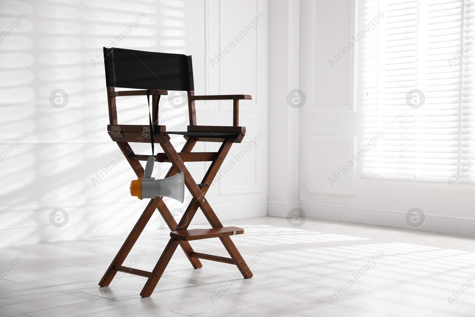 Photo of Director's chair with megaphone indoors, space for text