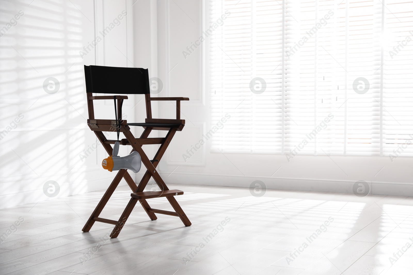 Photo of Director's chair with megaphone indoors, space for text