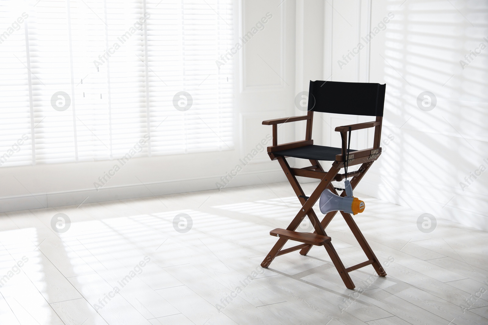 Photo of Director's chair with megaphone indoors, space for text