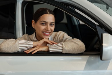 Photo of Happy woman inside new white car in salon