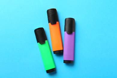 Photo of Bright highlighters on light blue background, flat lay