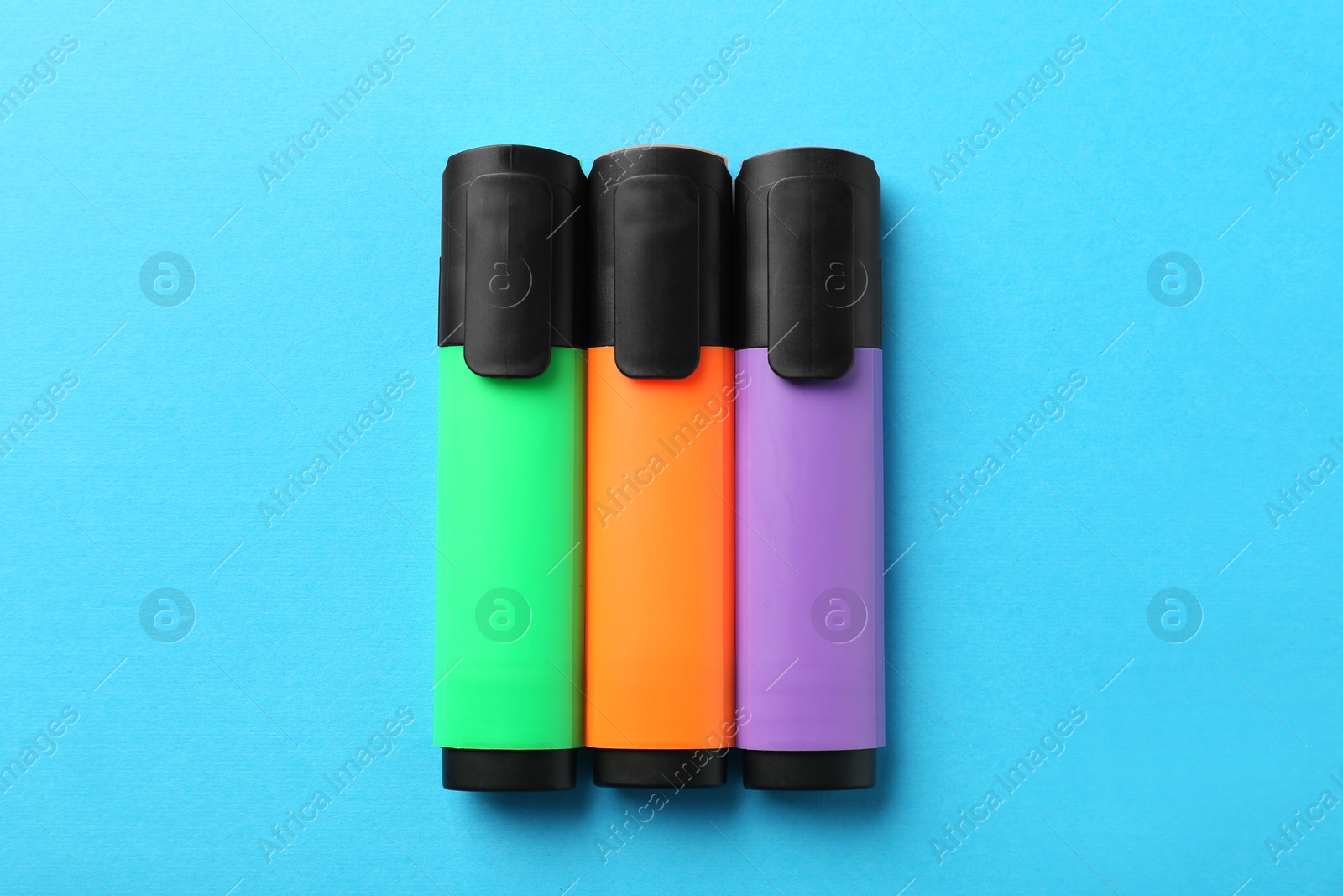 Photo of Bright highlighters on light blue background, flat lay