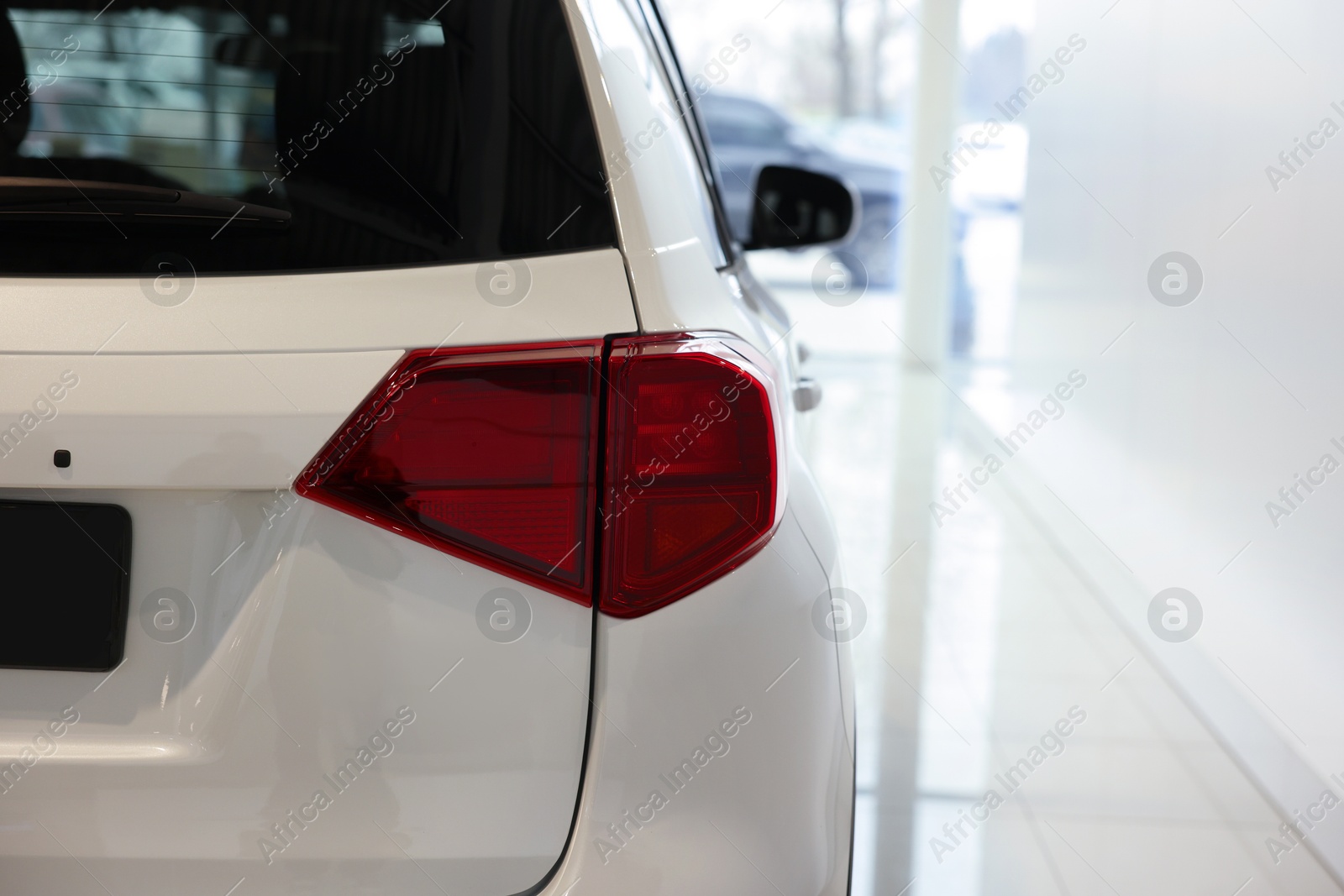 Photo of New modern white car in salon, closeup. Space for text