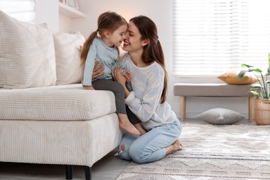 Happy mother with her cute little daughter at home