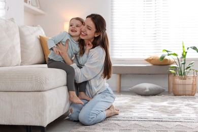 Happy mother with her cute little daughter at home