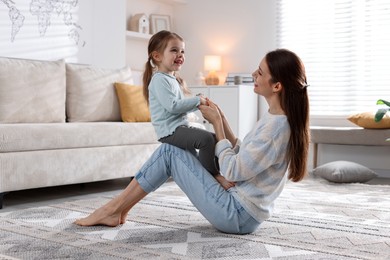 Photo of Happy mother having fun with her cute little daughter at home