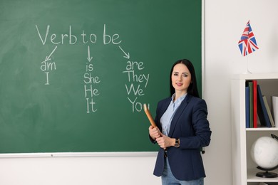 English teacher during lesson near chalkboard in classroom