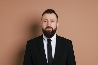 Handsome bearded man in suit on brown background