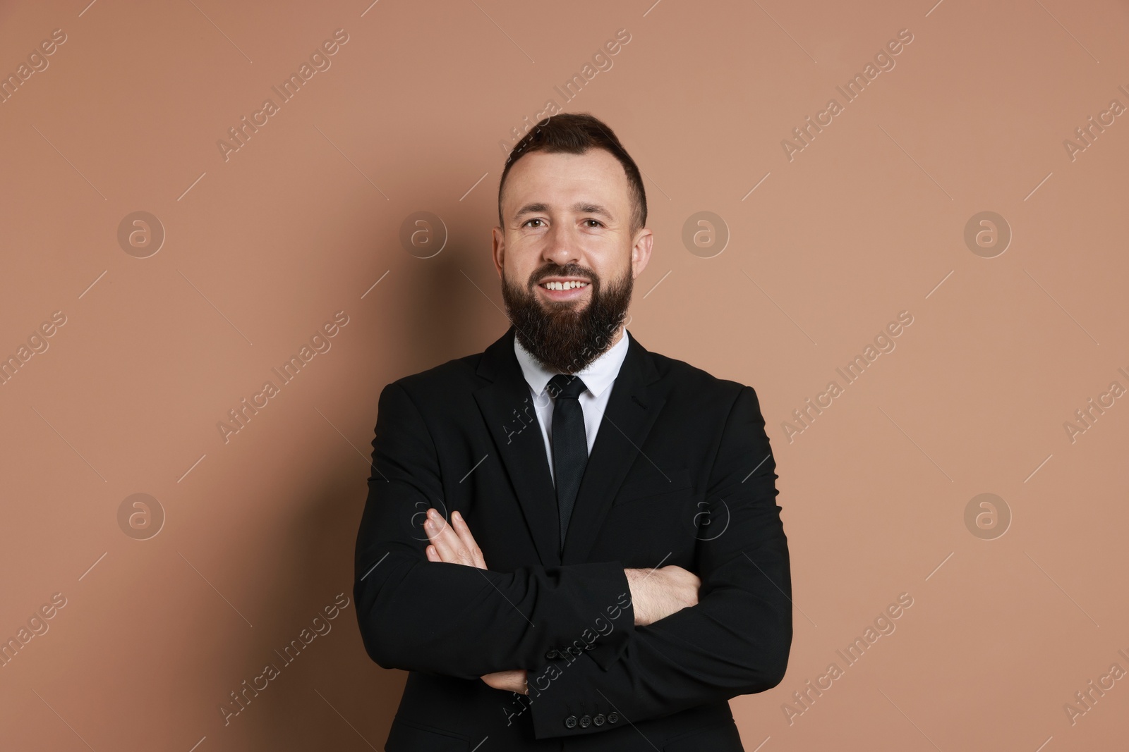 Photo of Handsome bearded man in suit on brown background