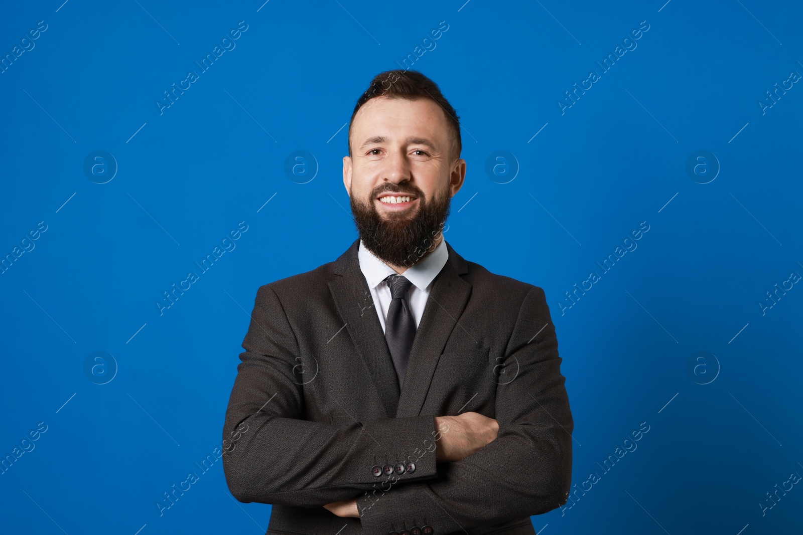 Photo of Handsome bearded man in suit on blue background