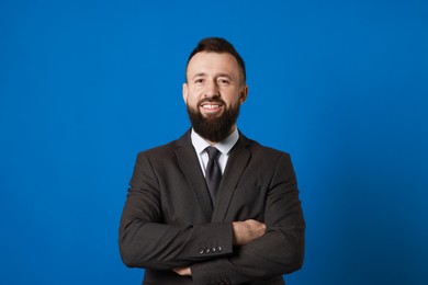 Handsome bearded man in suit on blue background