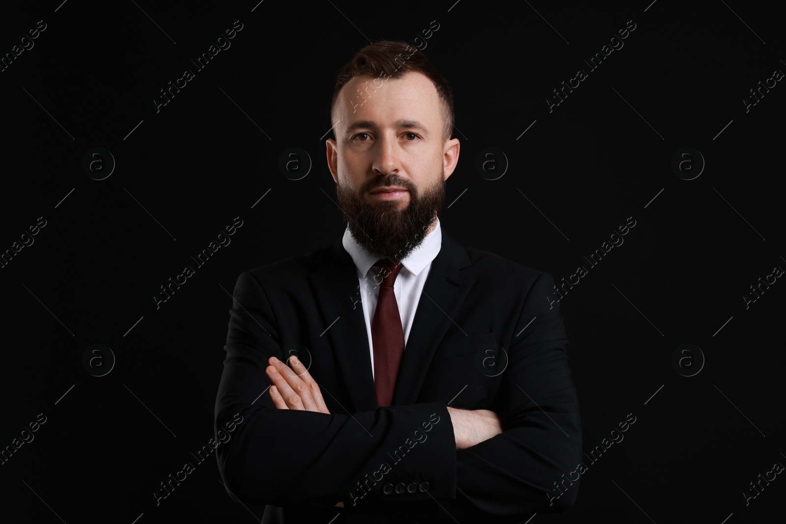 Photo of Handsome bearded man in suit on black background