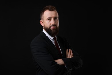 Photo of Handsome bearded man in suit on black background