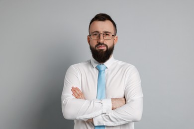 Handsome bearded man in formal outfit on grey background