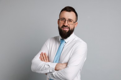 Handsome bearded man in formal outfit on grey background