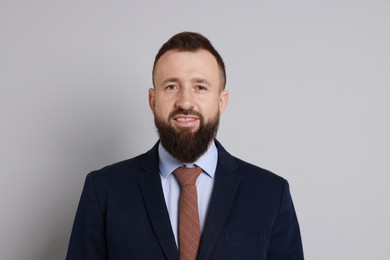 Handsome bearded man in suit on grey background