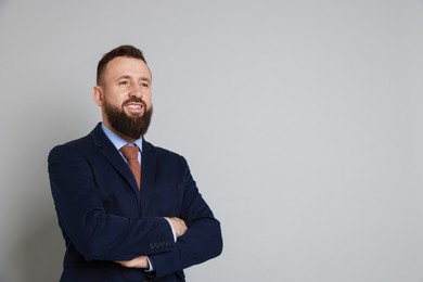 Photo of Handsome bearded man in suit on grey background. Space for text