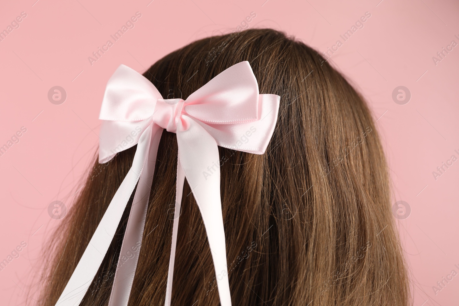 Photo of Woman with stylish hair bow on pink background, closeup