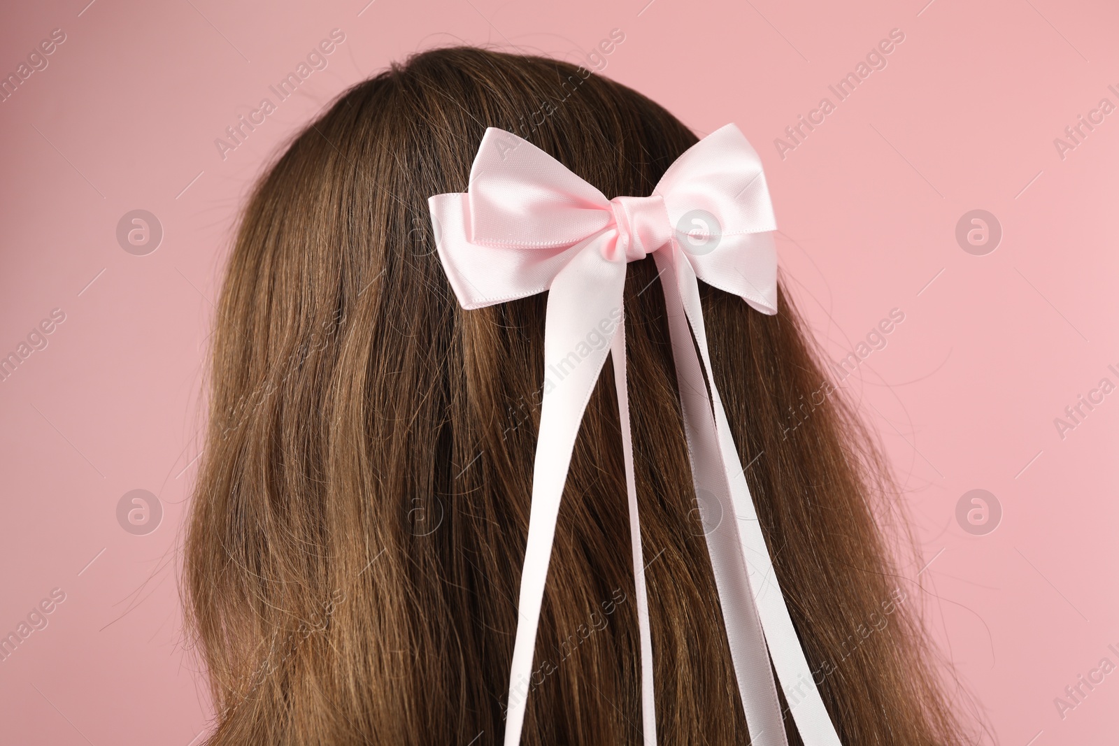 Photo of Woman with stylish hair bow on pink background, closeup