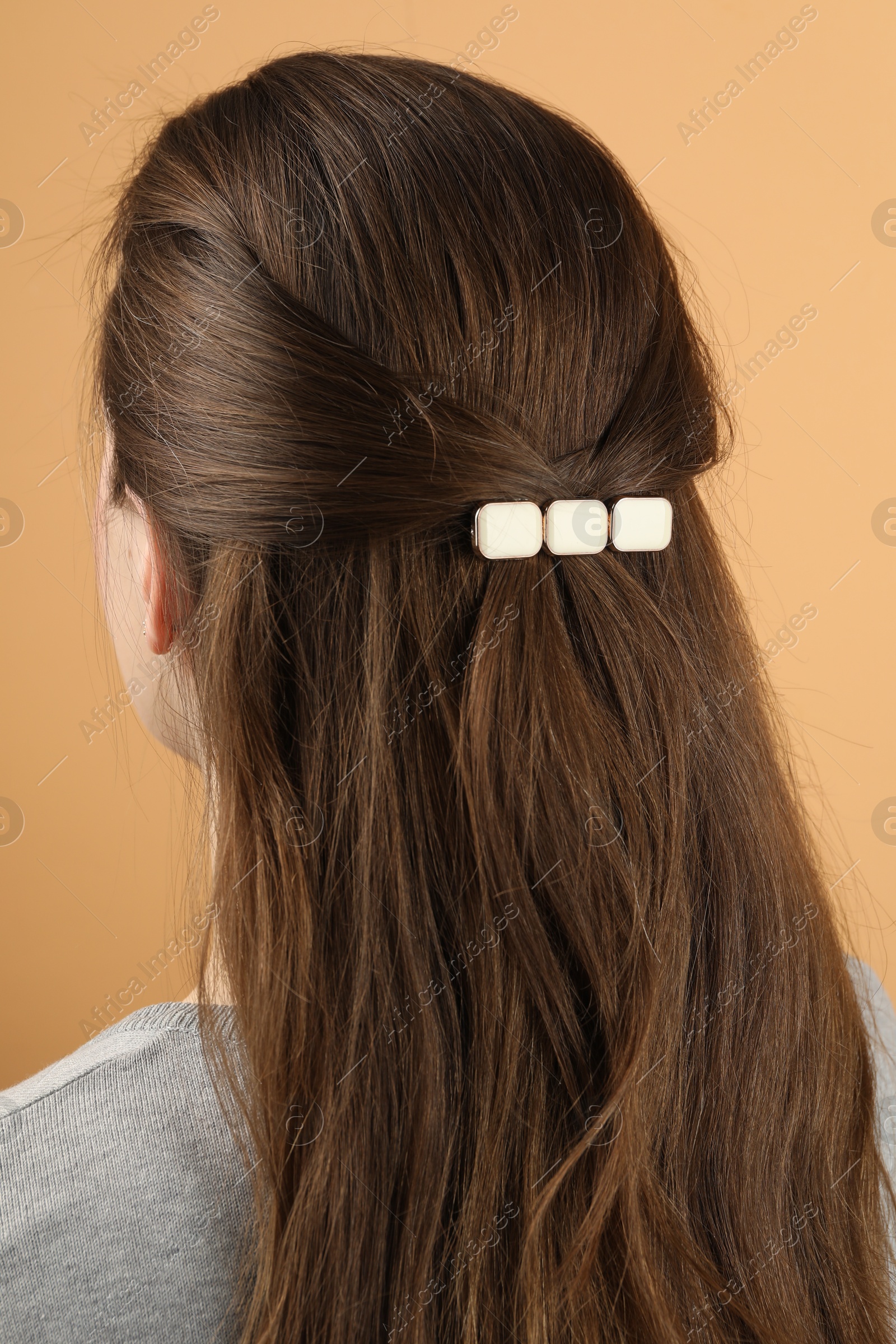 Photo of Woman with beautiful hair clip on beige background, back view