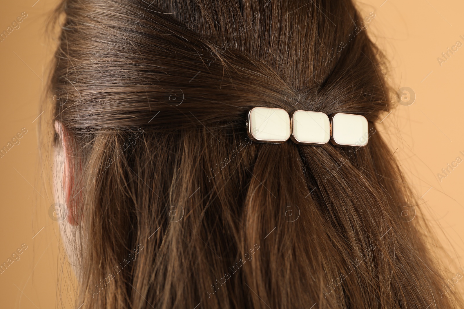 Photo of Woman with beautiful hair clip on beige background, closeup