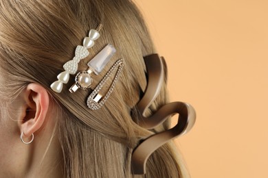 Photo of Woman with beautiful hair clips on beige background, closeup. Space for text