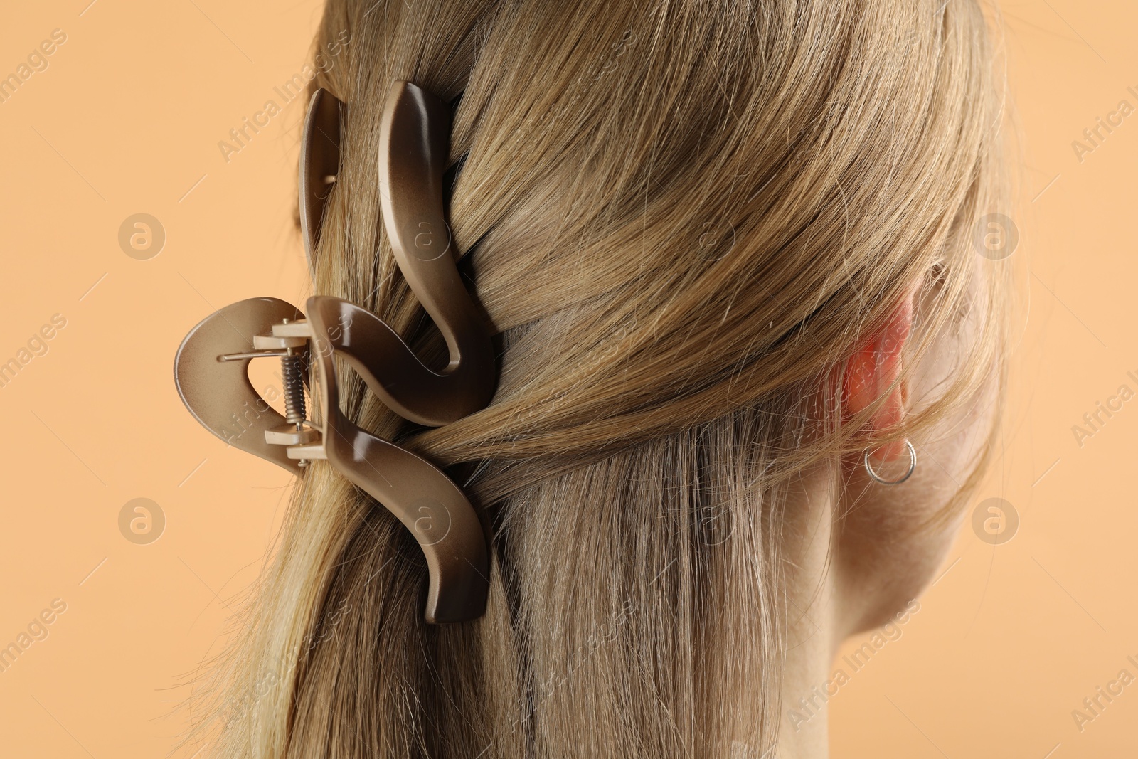 Photo of Woman with beautiful hair clip on beige background, closeup