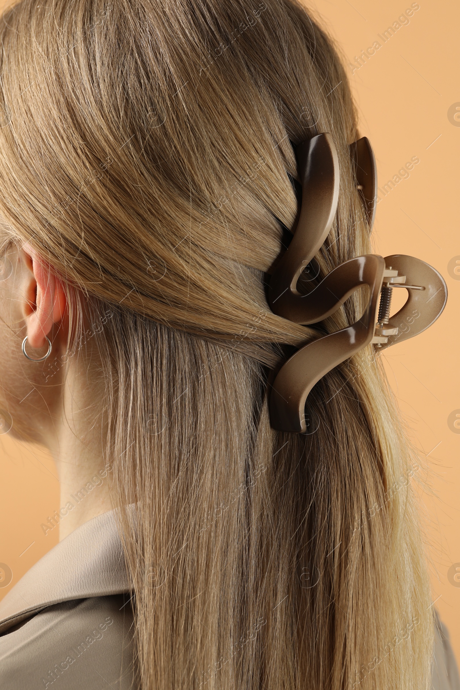 Photo of Woman with beautiful hair clip on beige background, closeup