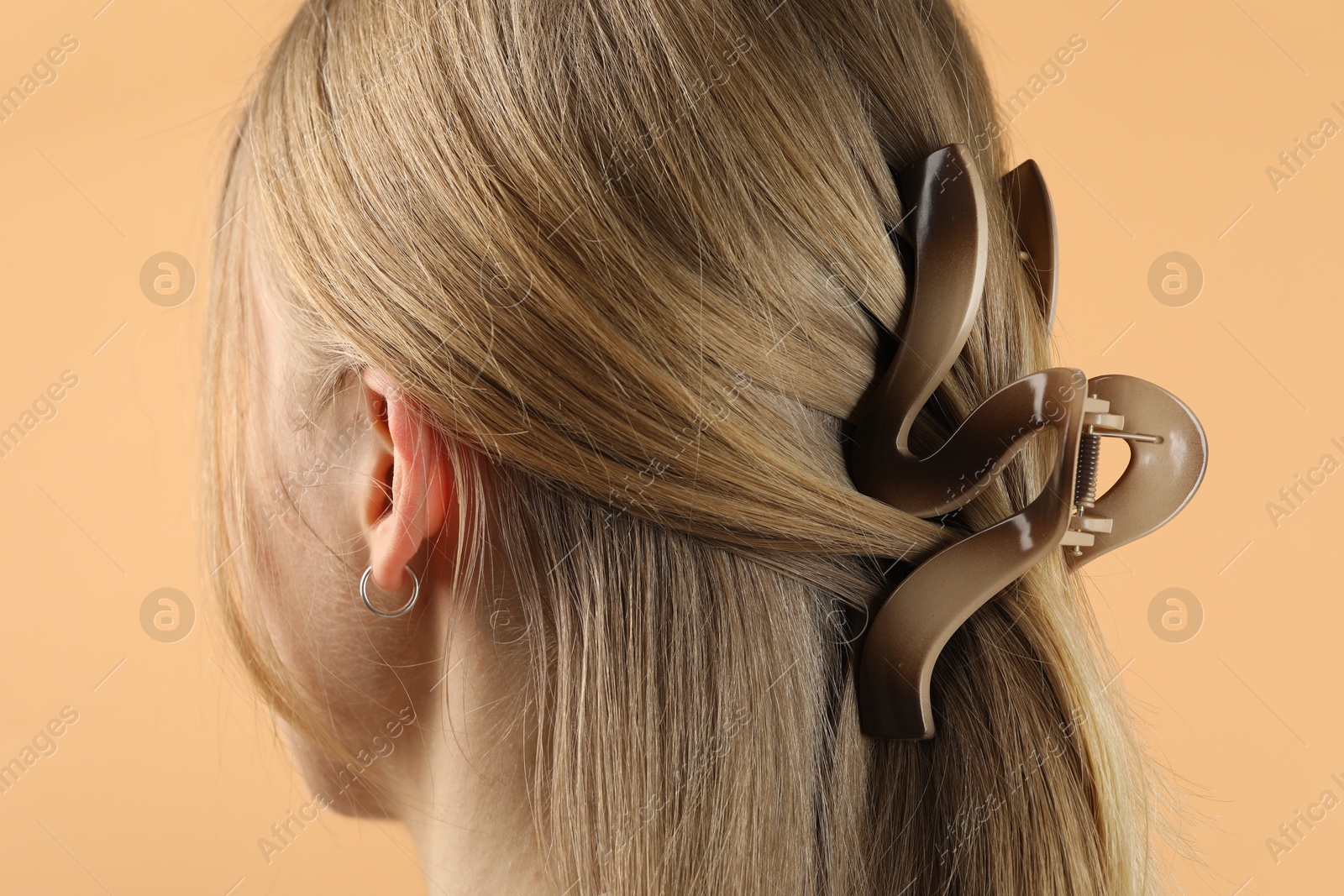 Photo of Woman with beautiful hair clip on beige background