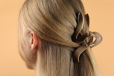 Photo of Woman with beautiful hair clip on beige background