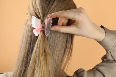 Photo of Woman with beautiful hair clip on beige background, back view