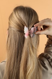 Photo of Woman with beautiful hair clip on beige background, back view