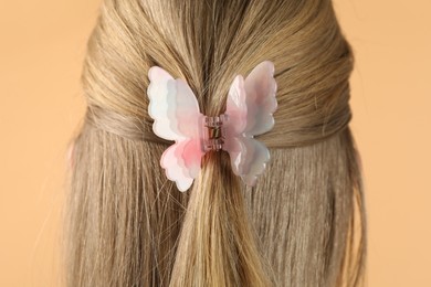 Photo of Woman with beautiful hair clip on beige background, closeup