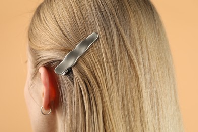 Photo of Woman with beautiful hair clip on beige background, closeup