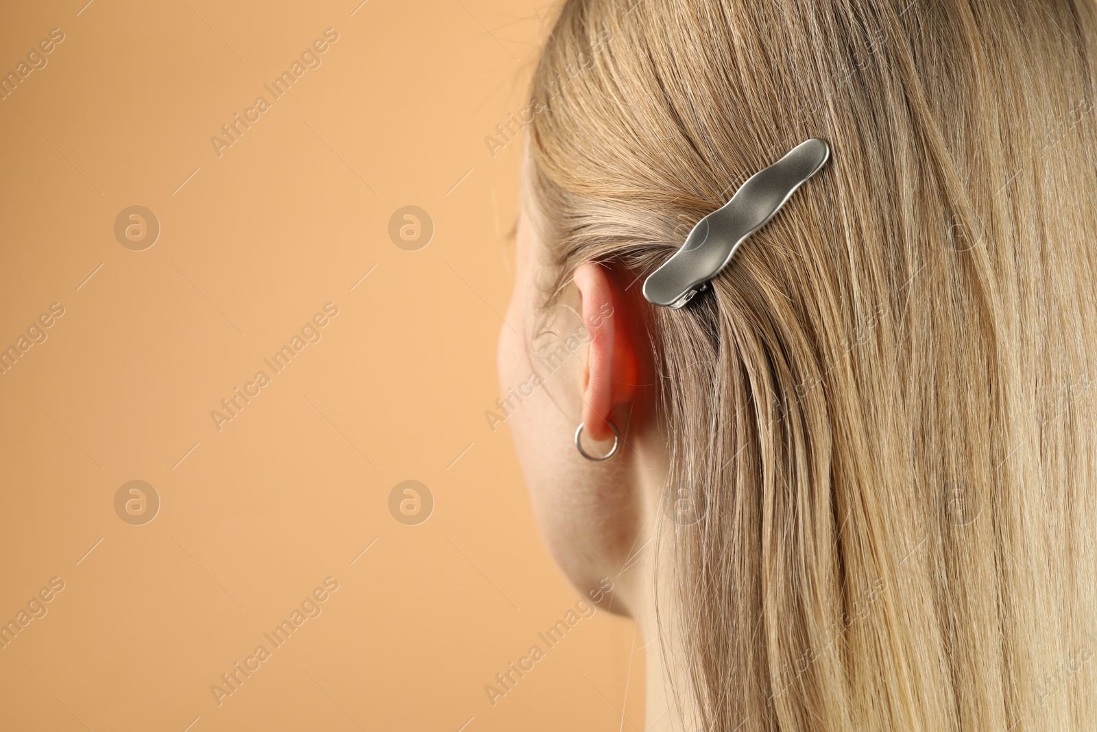 Photo of Woman with beautiful hair clip on beige background, closeup. Space for text