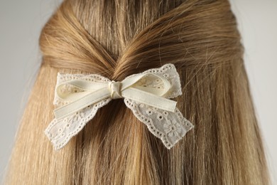 Photo of Woman with beautiful hair bow on light grey background, back view