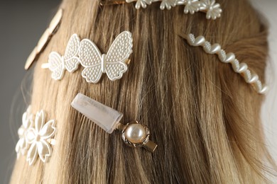 Photo of Woman with beautiful hair clips on grey background, closeup