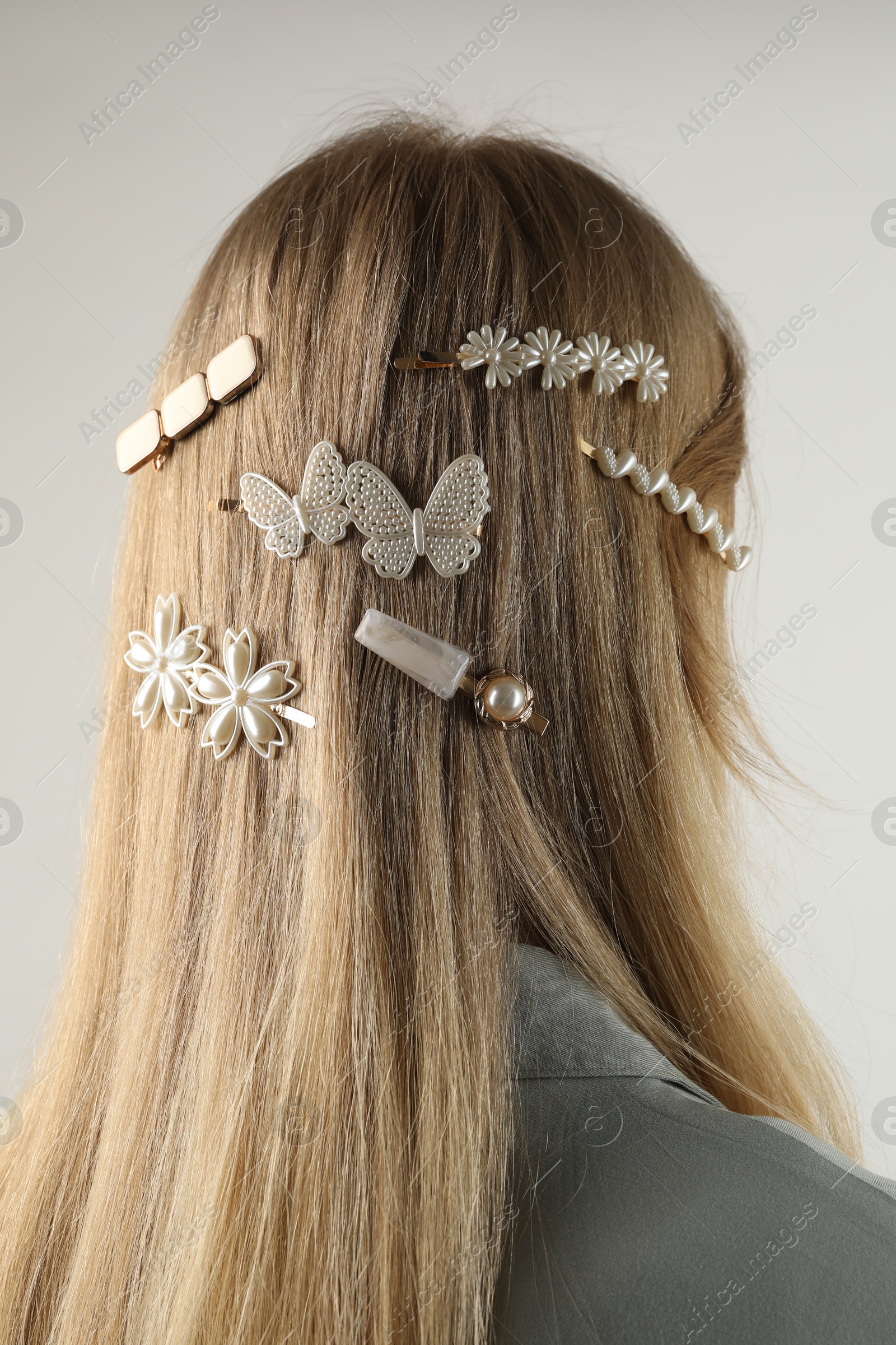 Photo of Woman with beautiful hair clips on light grey background