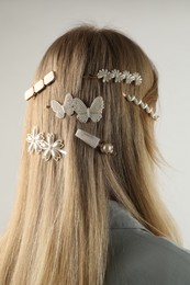 Photo of Woman with beautiful hair clips on light grey background