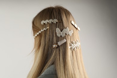 Woman with beautiful hair clips on light grey background