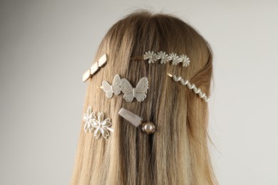 Photo of Woman with beautiful hair clips on light grey background, back view