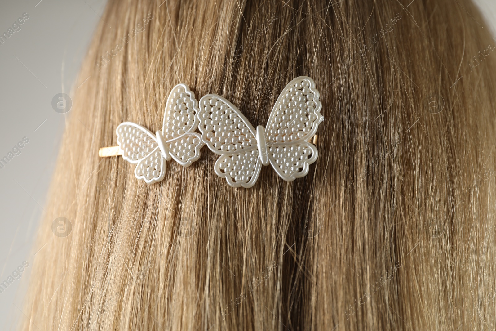 Photo of Woman with beautiful hair clip on light grey background, closeup