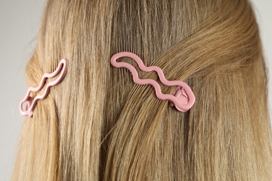 Photo of Woman with beautiful hair clips on light grey background, closeup